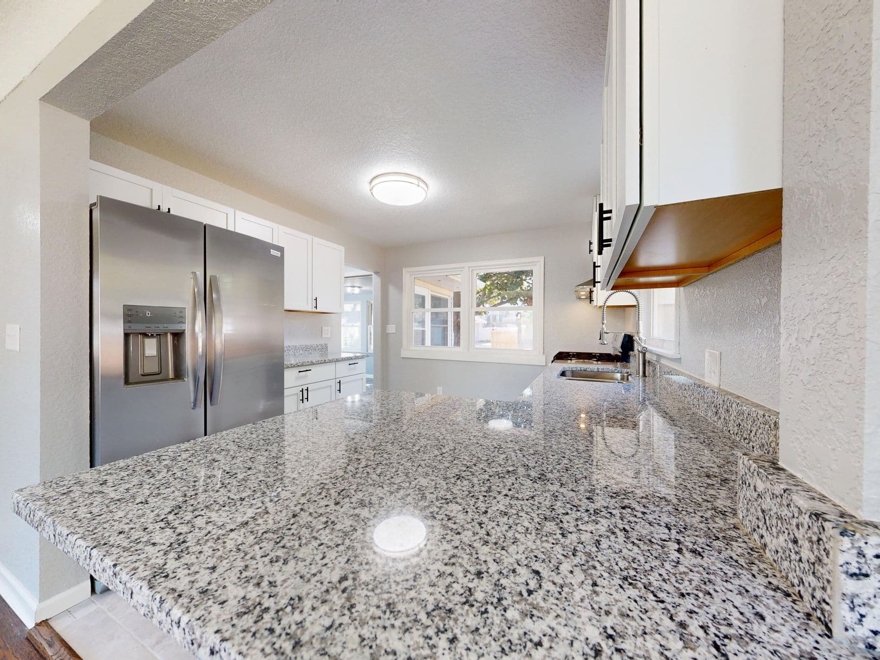 Spacious kitchen featuring granite countertops and stainless steel appliances.
